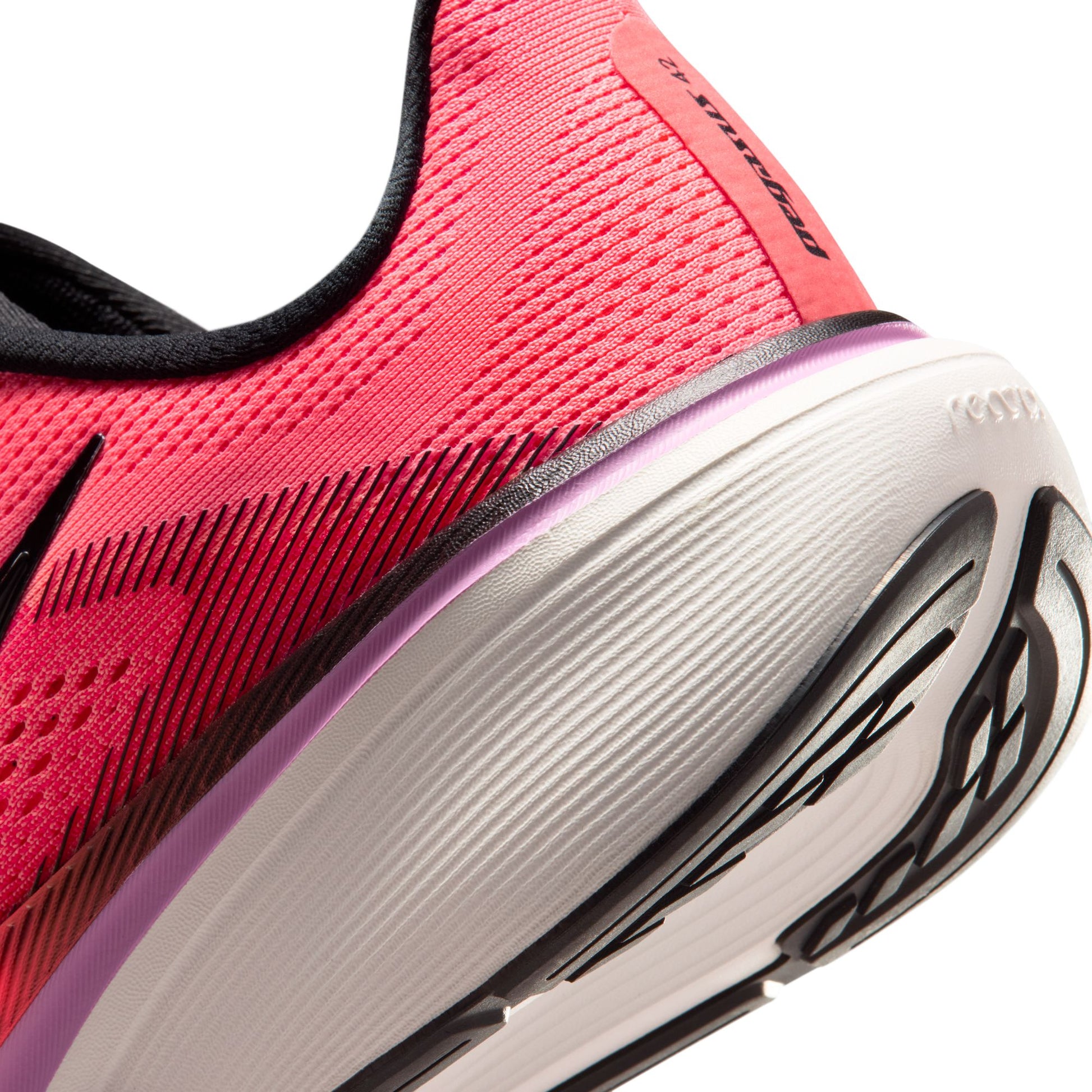 Close-up of a pink running shoe with white sole on a white background