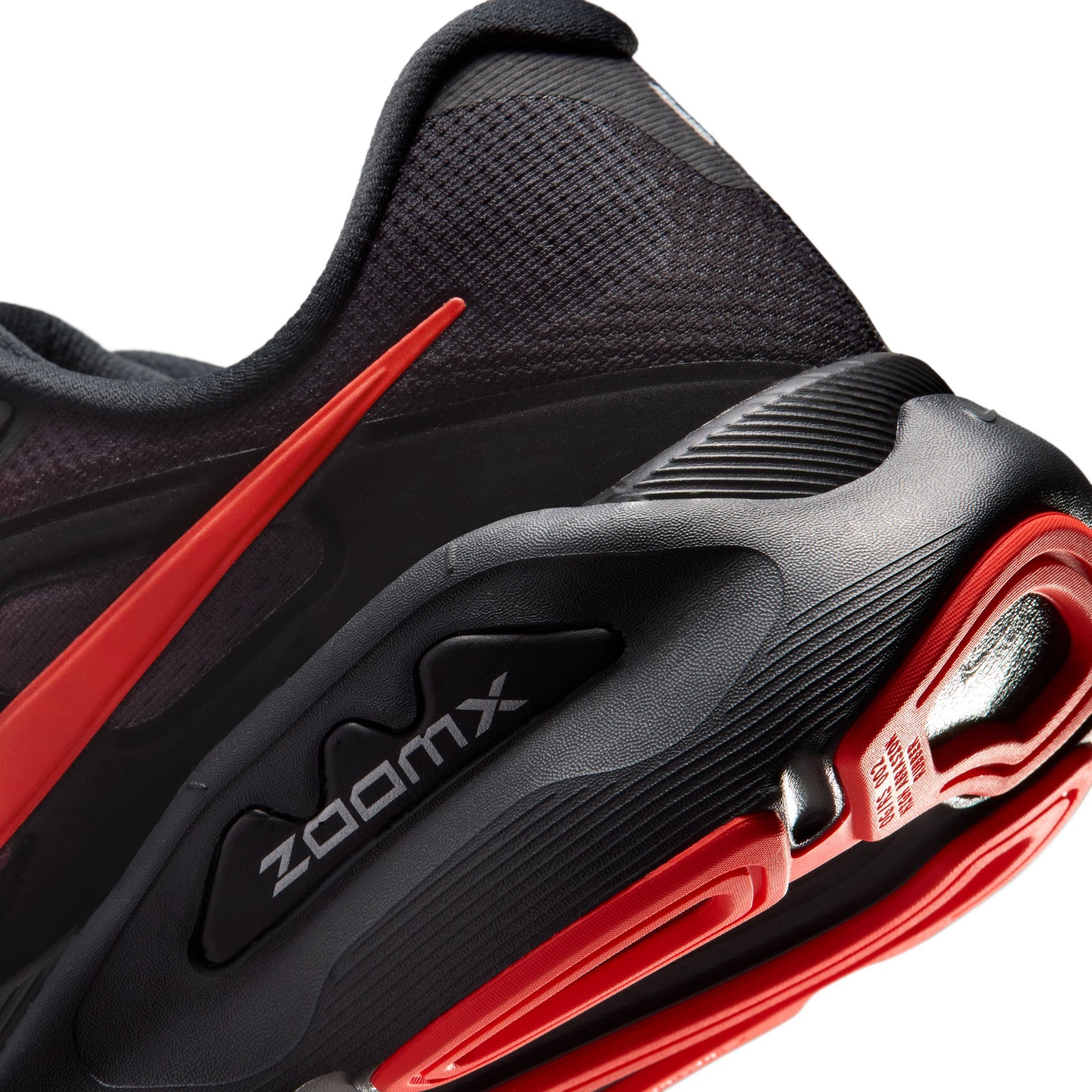 Black and red athletic shoe with 'zoomx' branding on a white background