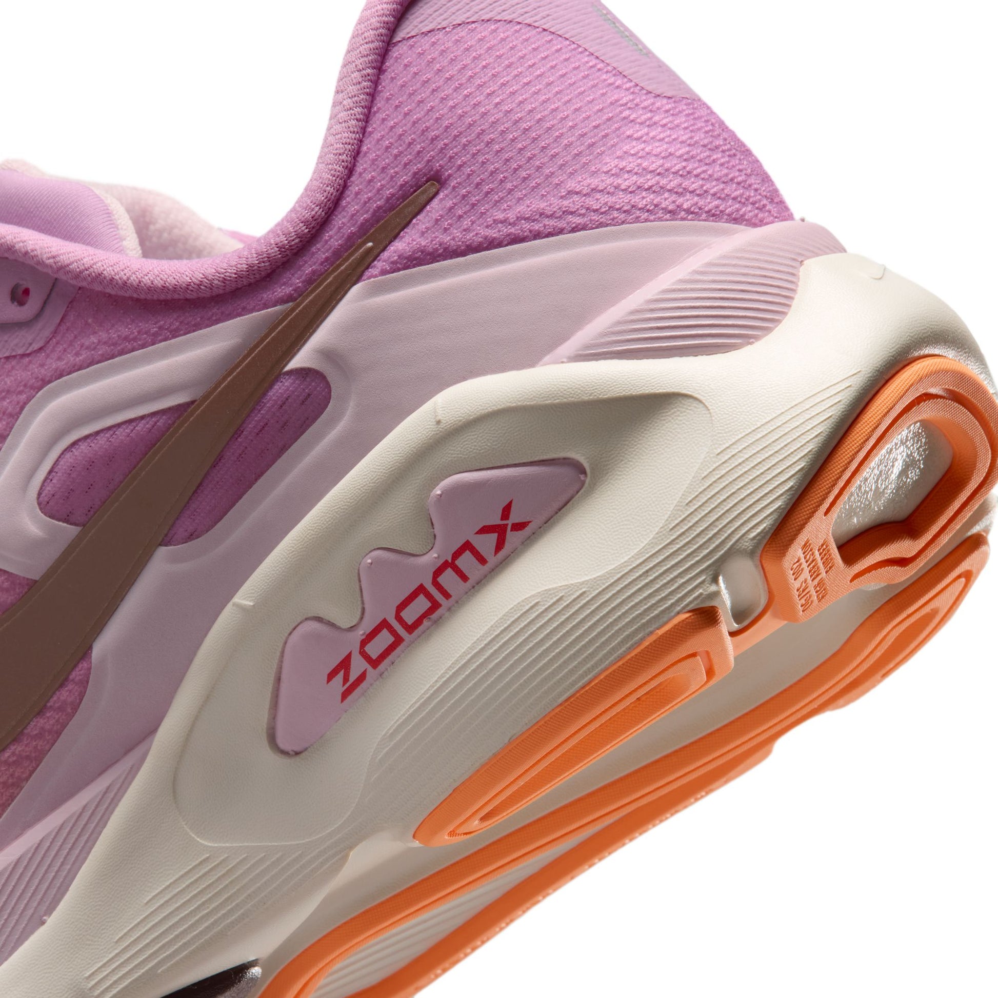 Close-up of a purple running shoe with orange and white sole, featuring the 'ZoomX' logo.