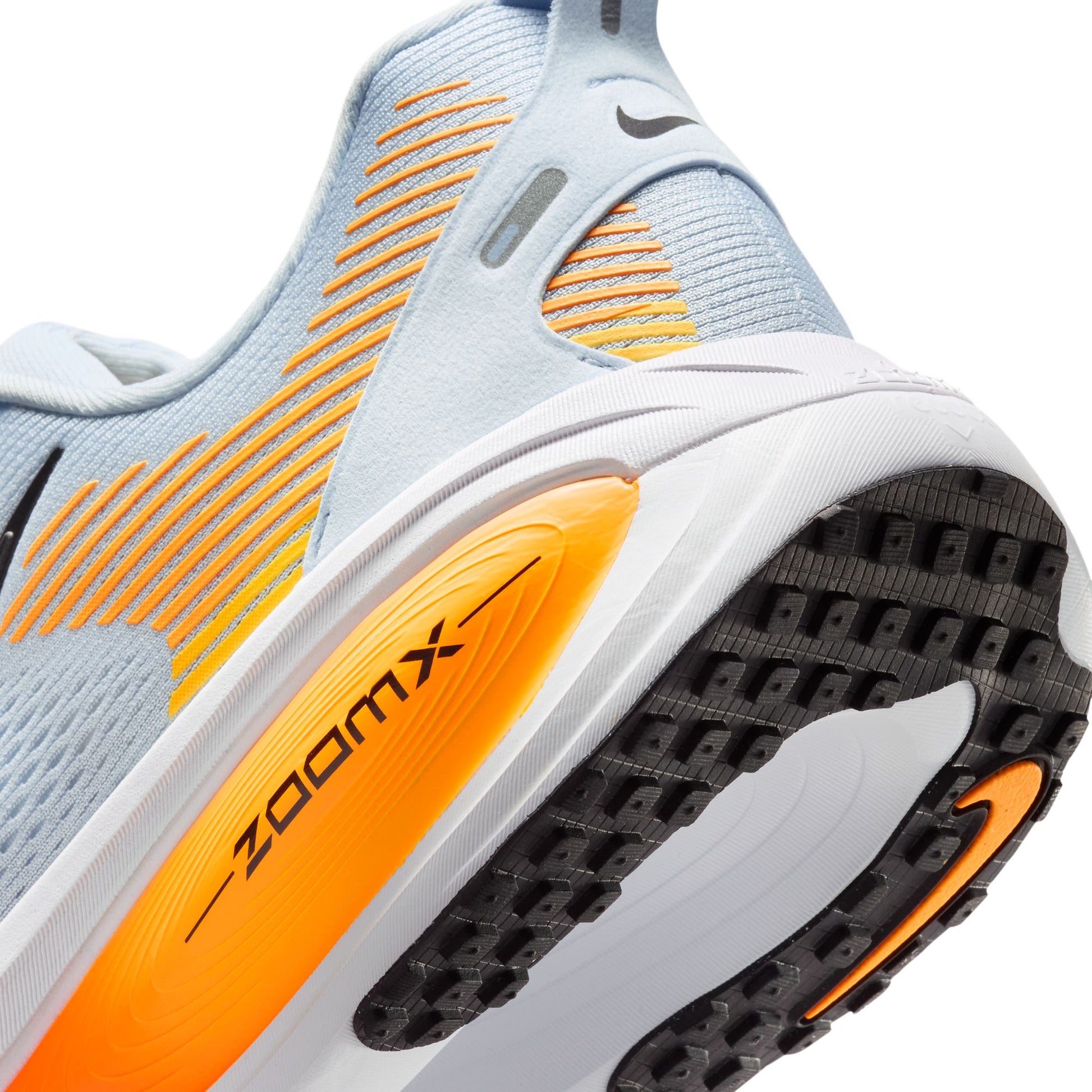 Close-up of a running shoe with orange and black sole on a white background