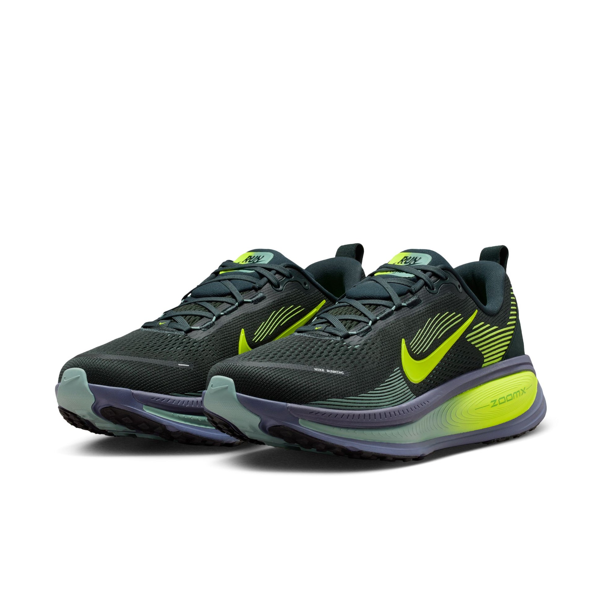 Pair of black and green running shoes on a white background