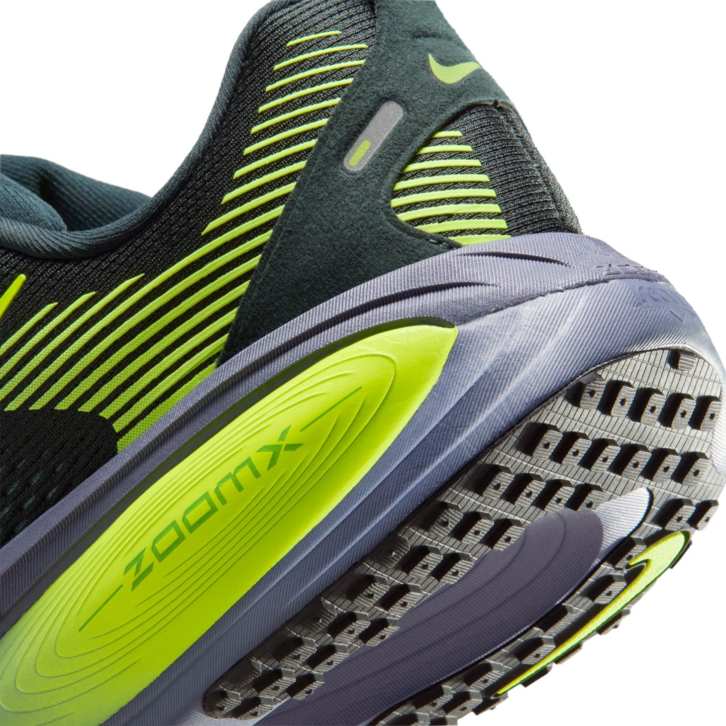 Close-up of a running shoe with green and gray sole and 'ZoomX' branding.