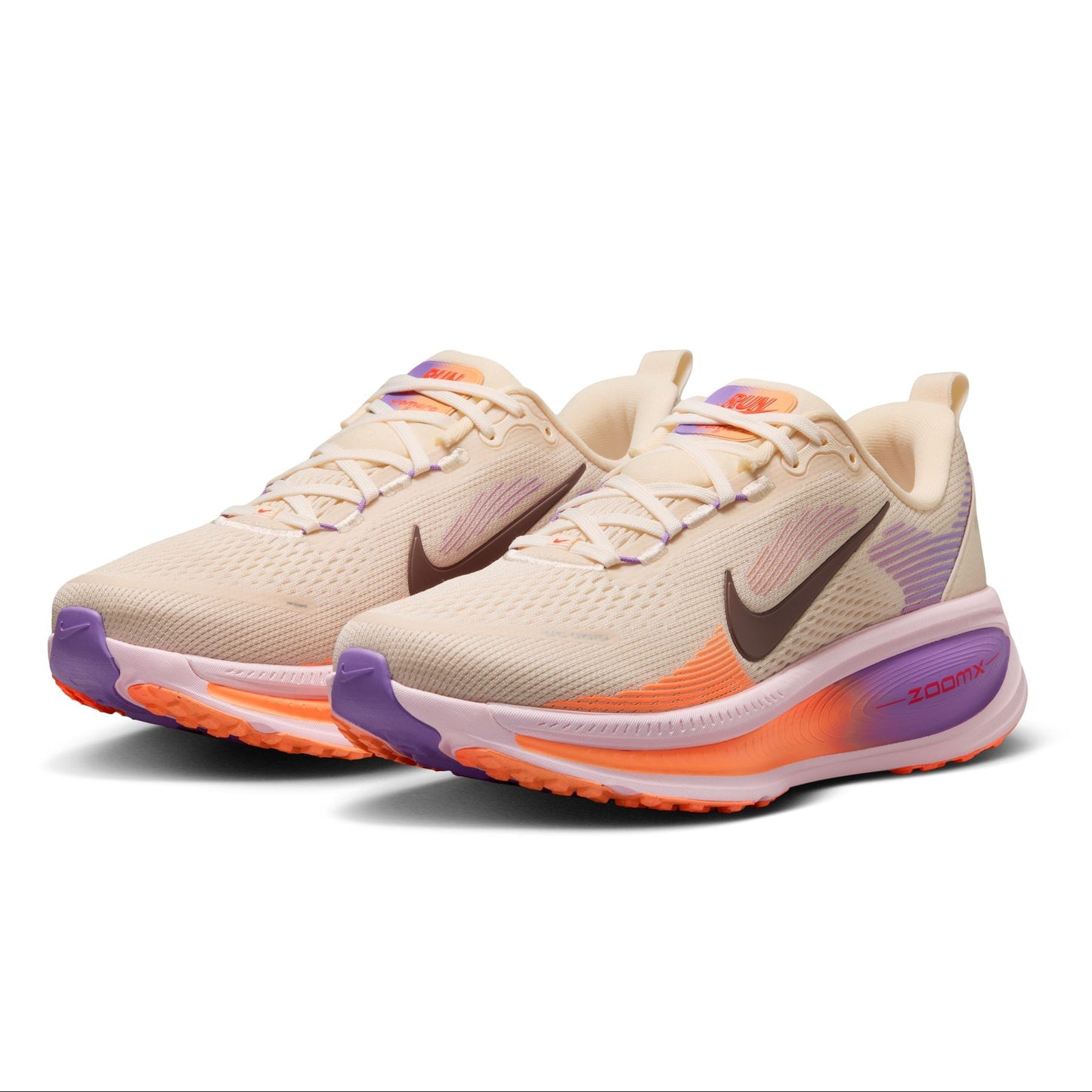 Beige running shoes with colorful soles on a white background