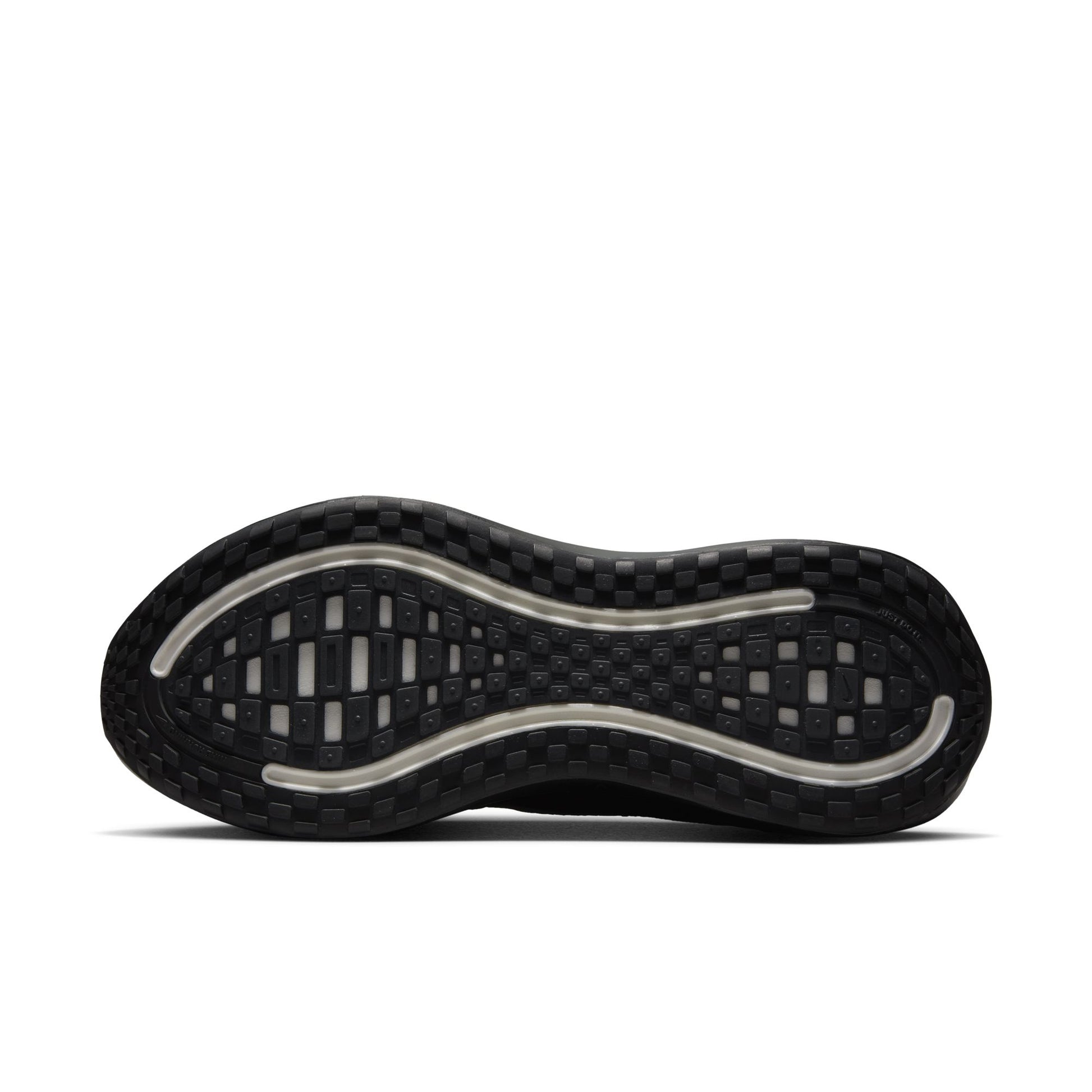 Close-up of a black shoe sole with tread pattern on a white background