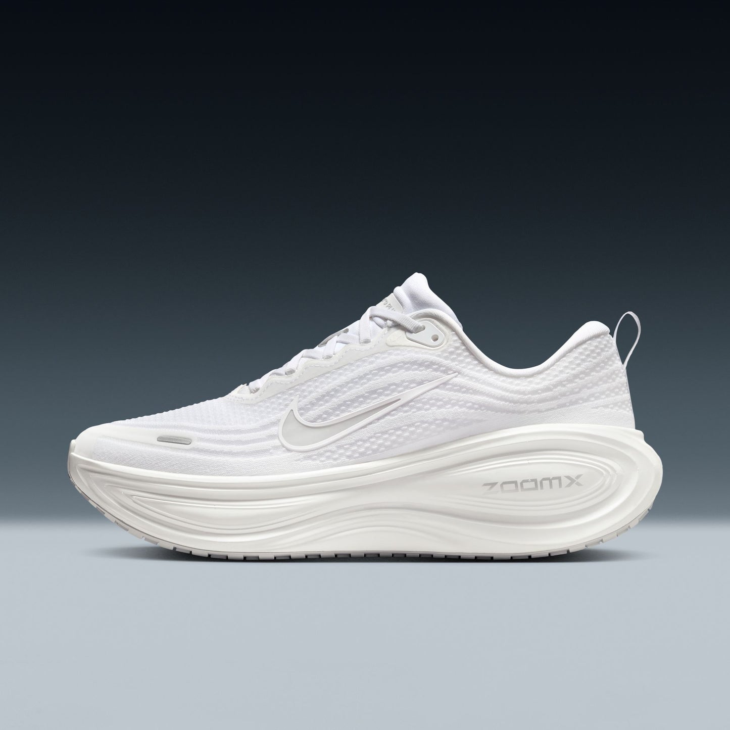 White running shoe with 'ZoomX' branding on a gradient background