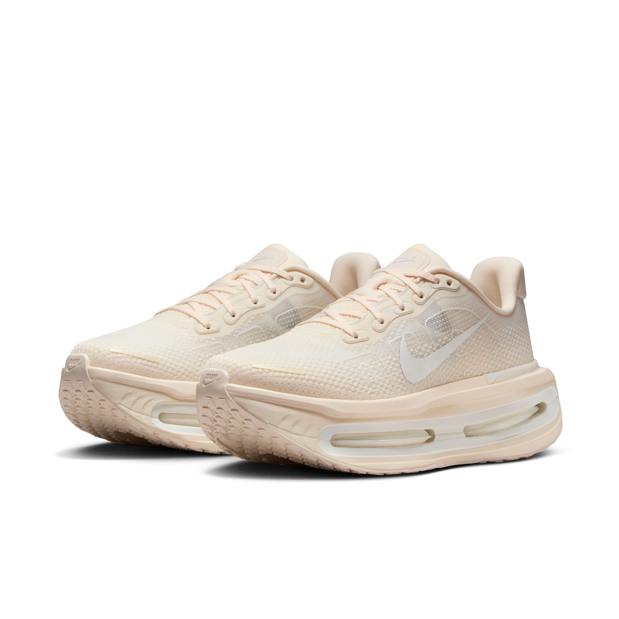Pair of beige running shoes on a white background