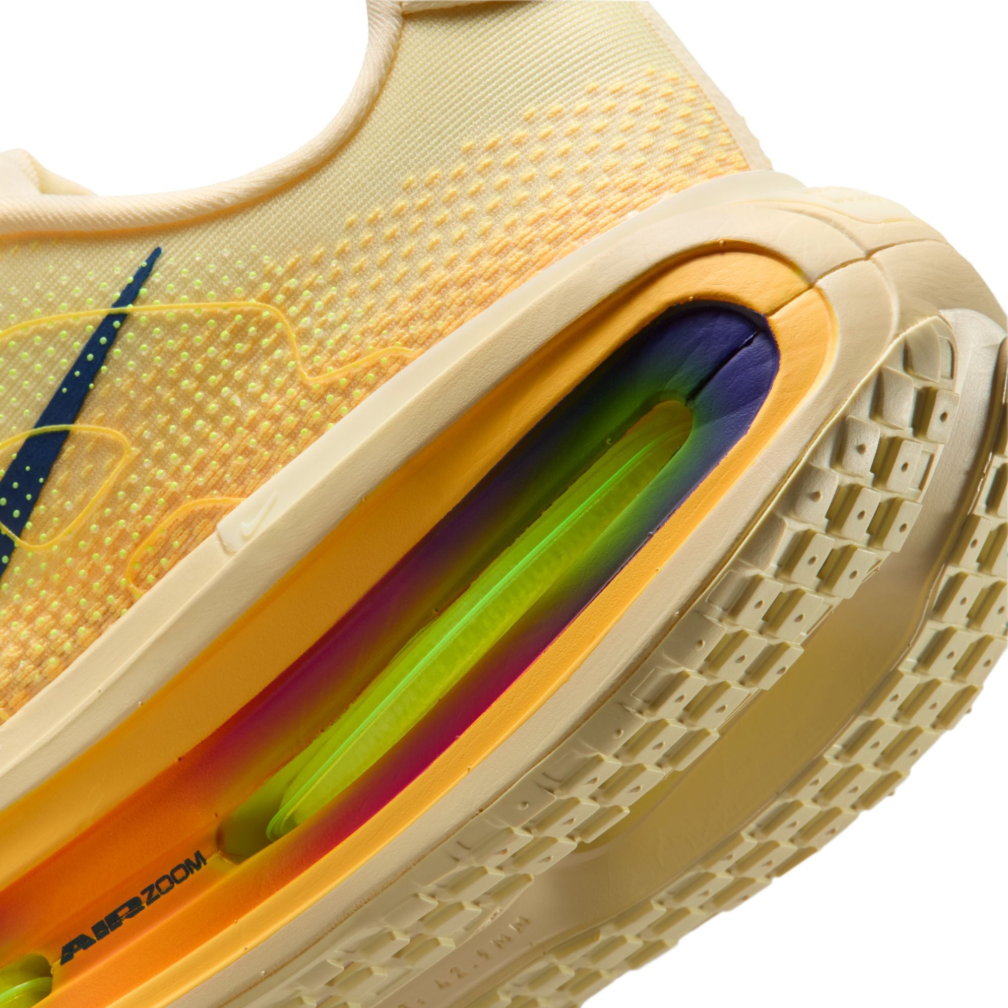 Close-up of a yellow sneaker with colorful sole and Nike logo.
