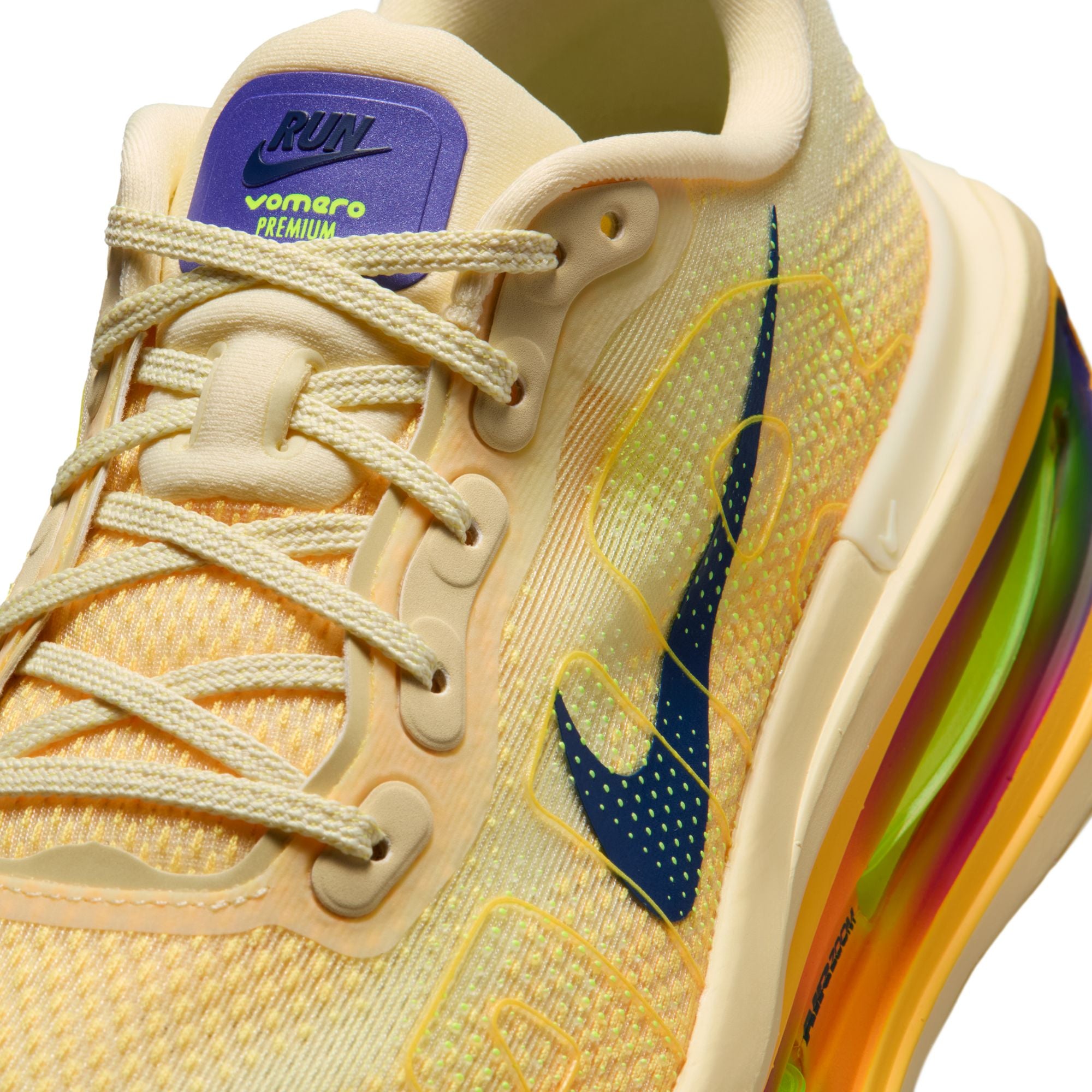 Beige running shoe with colorful sole on a white background