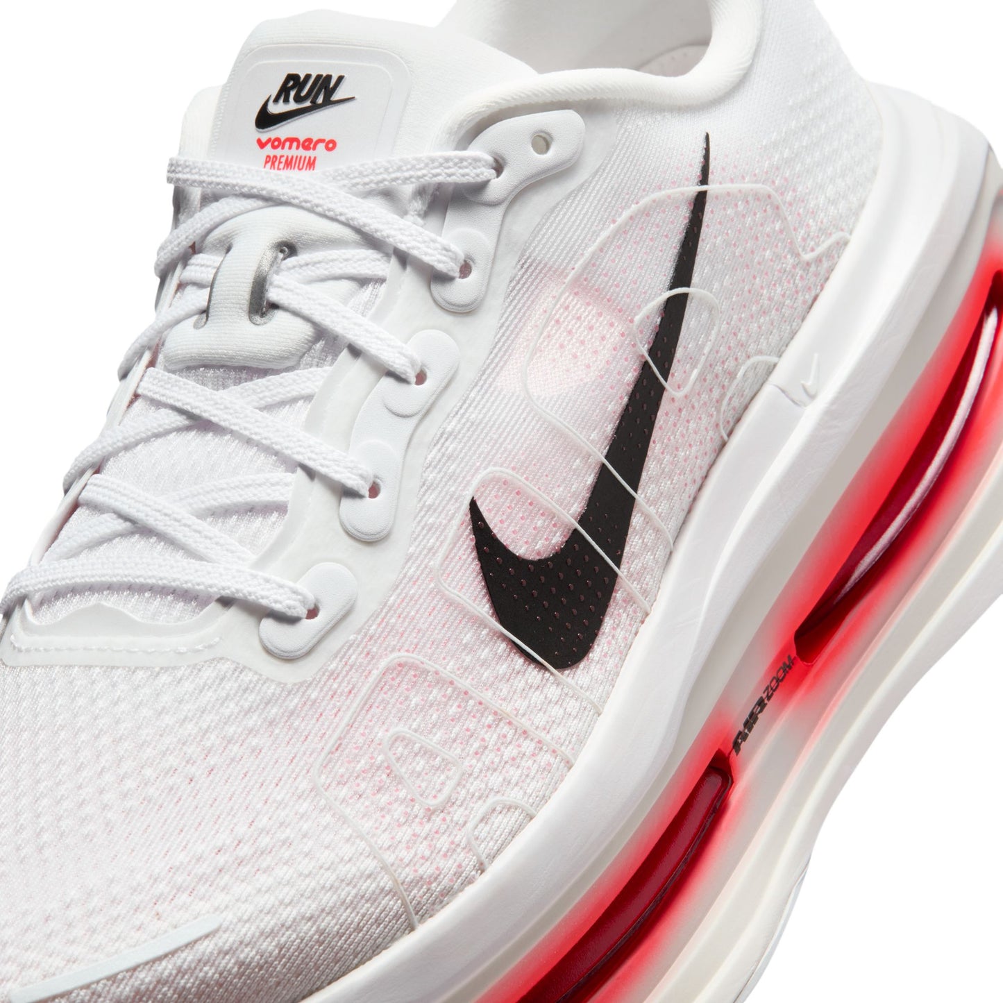 White sneaker with black swoosh logo and red accents on a white background