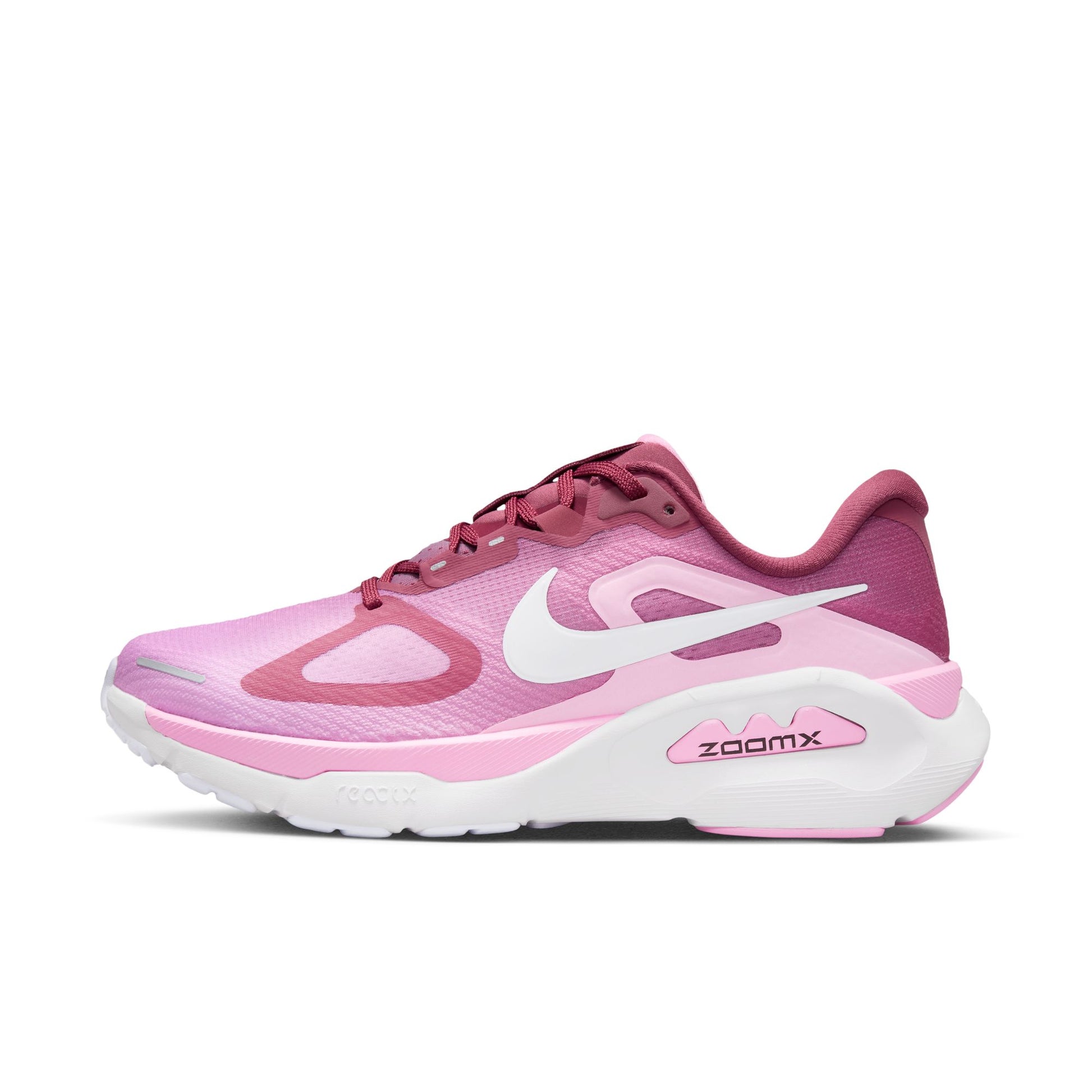 Pink and white running shoe with 'zoomx' on a white background